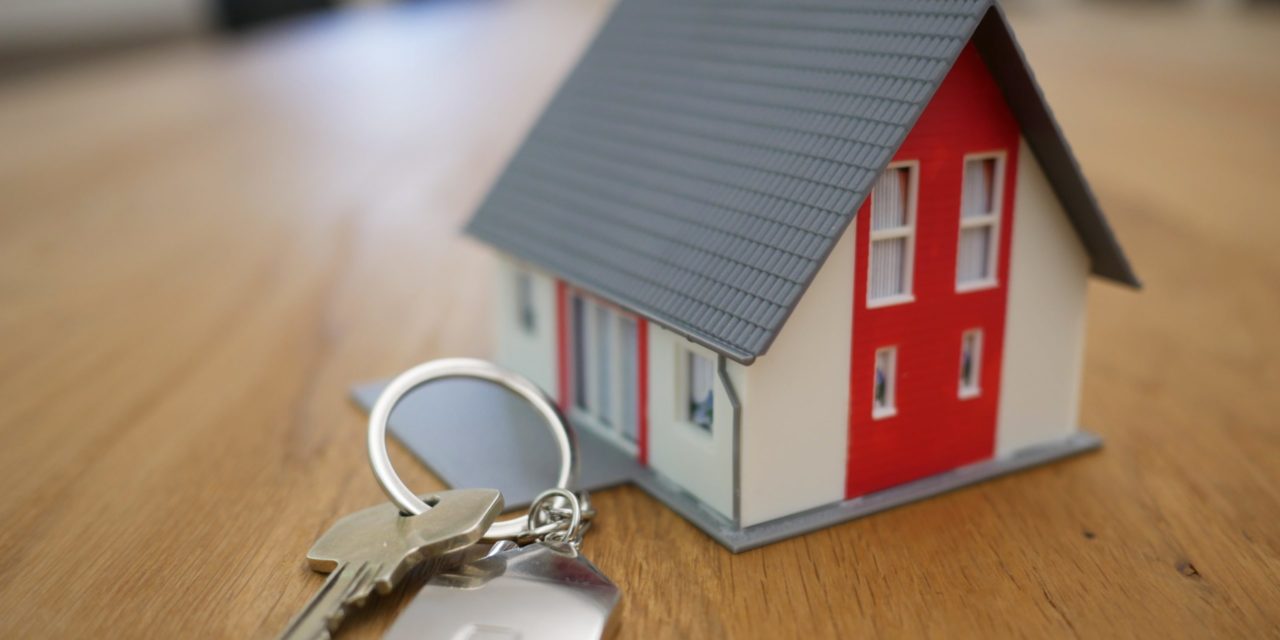 A small, model house next to a set of keys