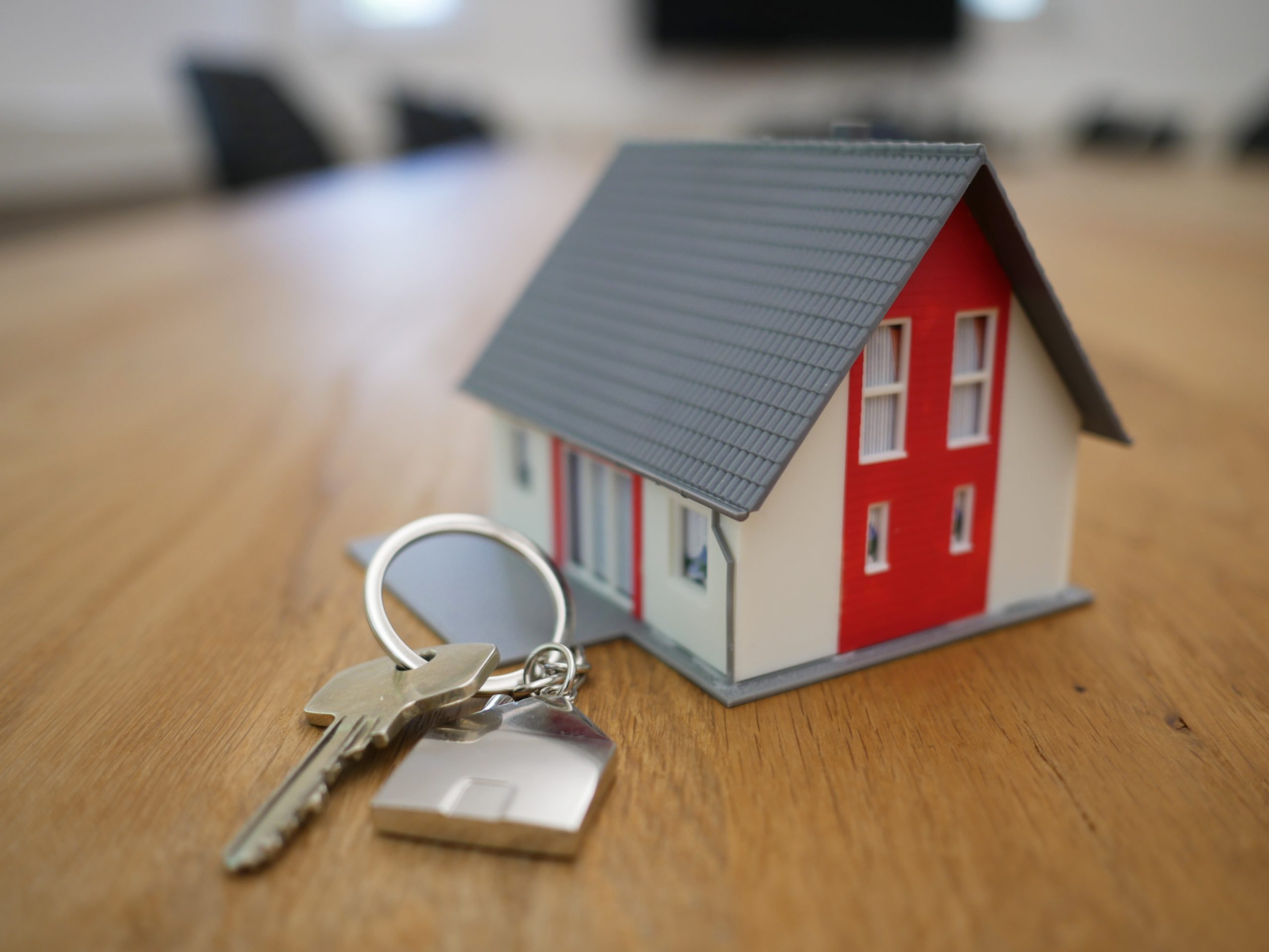 A small, model house next to a set of keys